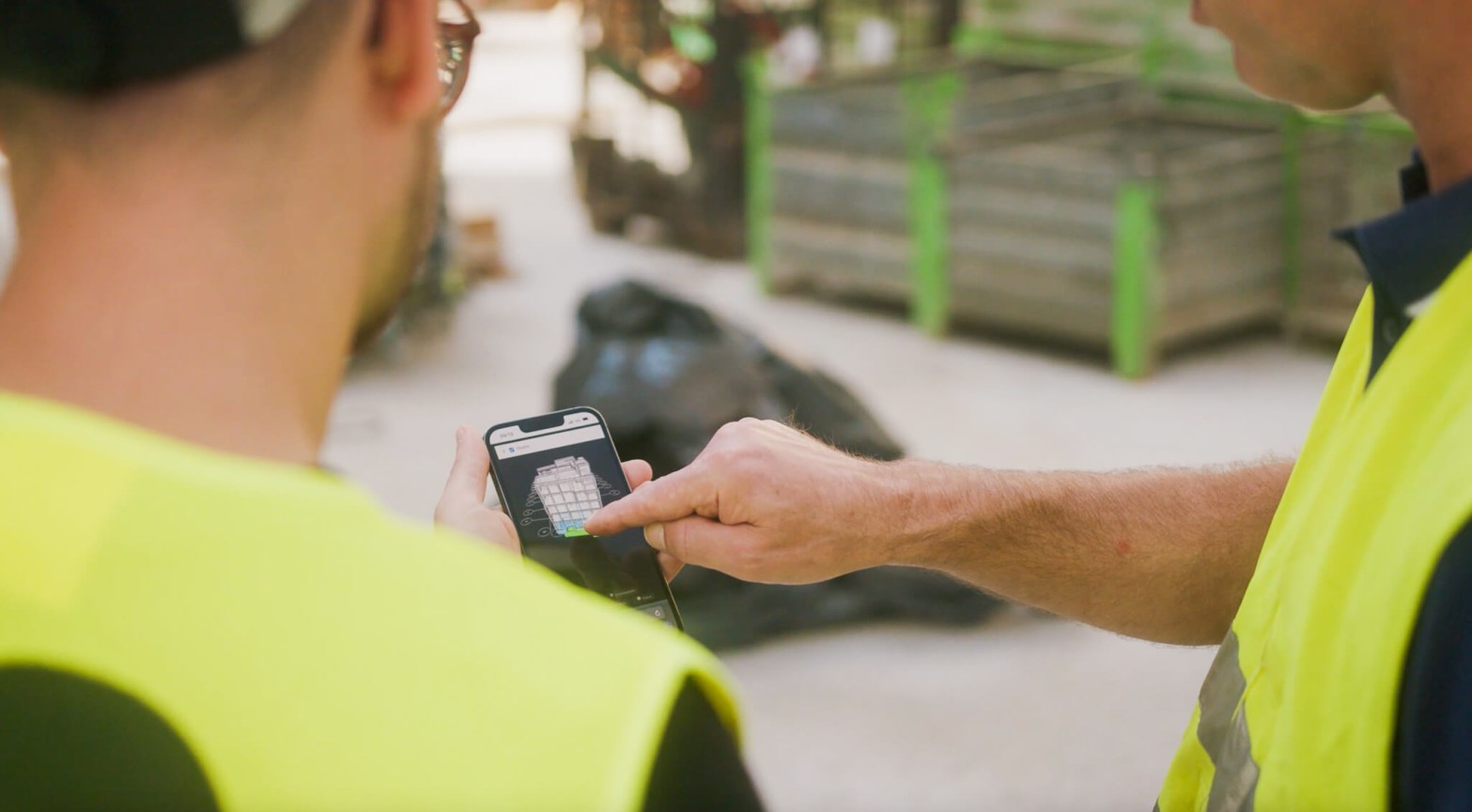 Bauleiter arbeitet mit specter automation auf der Baustelle, um Prozesse digital abzubilden und Zeit einzusparen. Er erklät die Bausoftware Vorteile in der Anwendung am Smartphone.