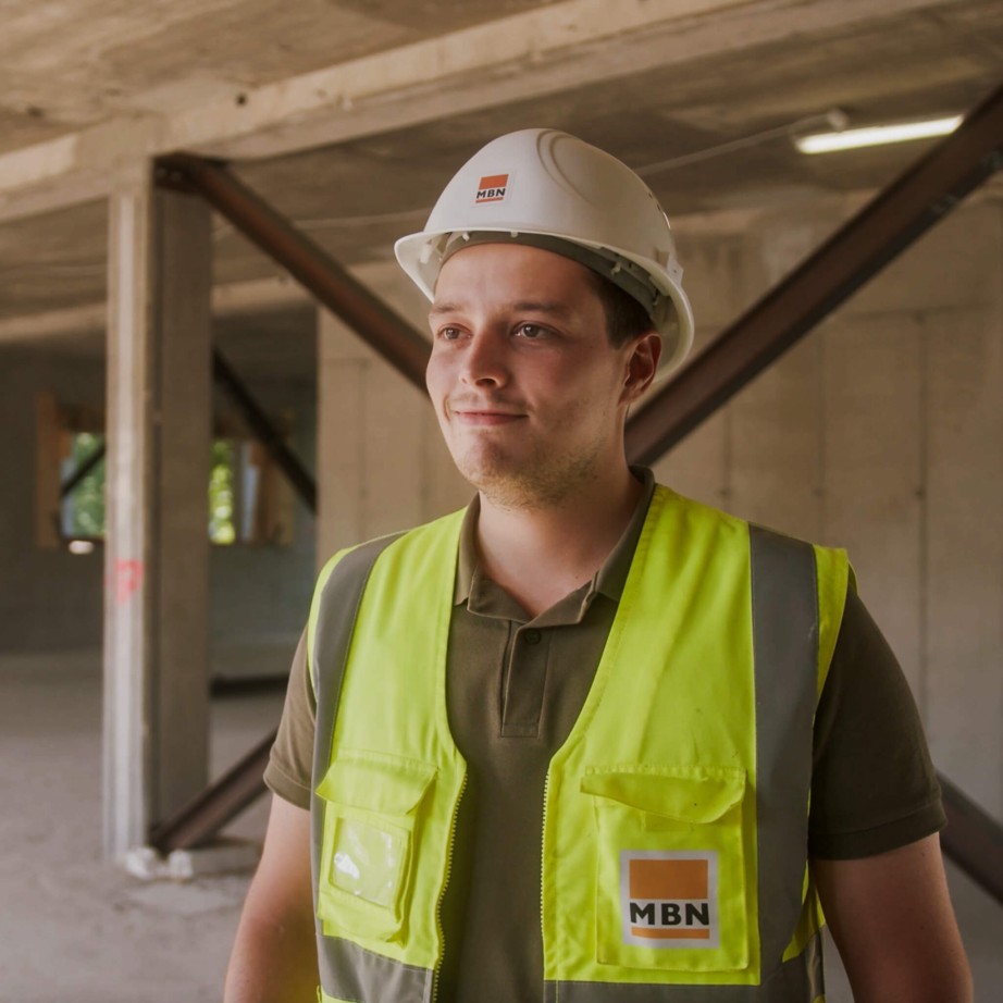 Bauleiter in Sicherheitsausrüstung auf der Baustelle mit der Bausoftware. Er arbeitet im Hochbau für das Bauunternehmen MBN.